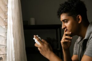 Man looking at medication bottle while worried about mixing Tylenol and alcohol