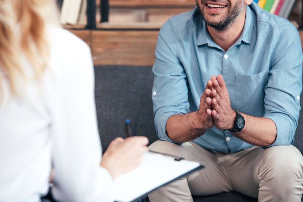 Man discussing health concerns related to Tylenol and alcohol with a therapist