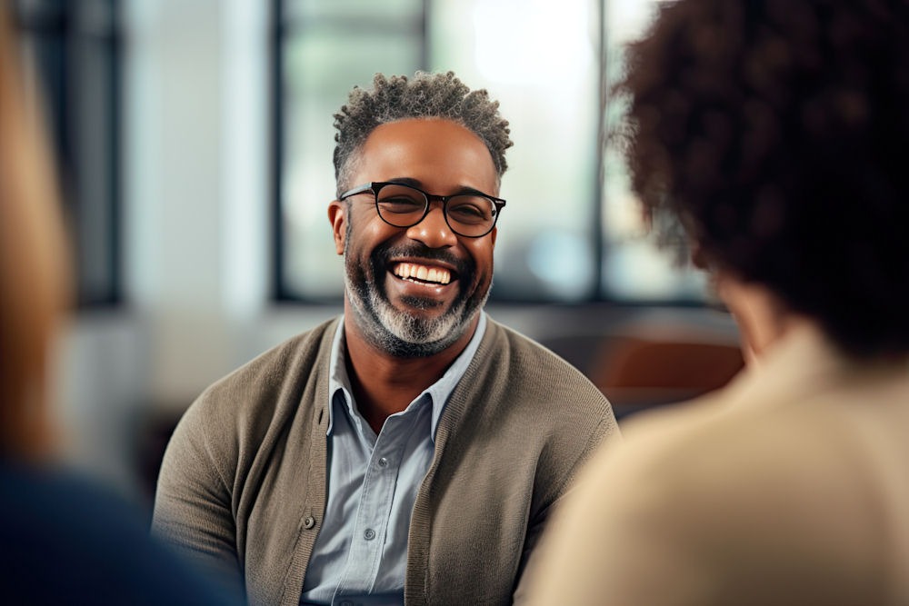 Smiling man enjoying group therapy during a sober vacation retreat