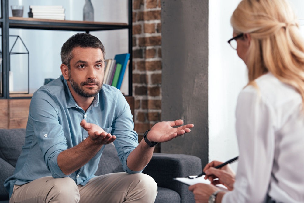 Man in therapy session expressing concerns about ambien side effects and dependency risks.