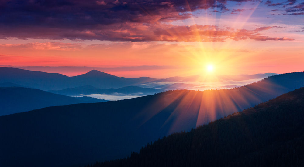 Panoramic view of colorful sunrise in mountains.