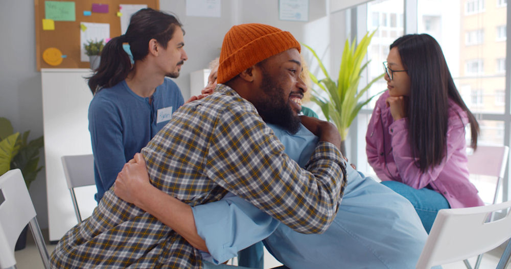 men embracing after alcohol addiction treatment