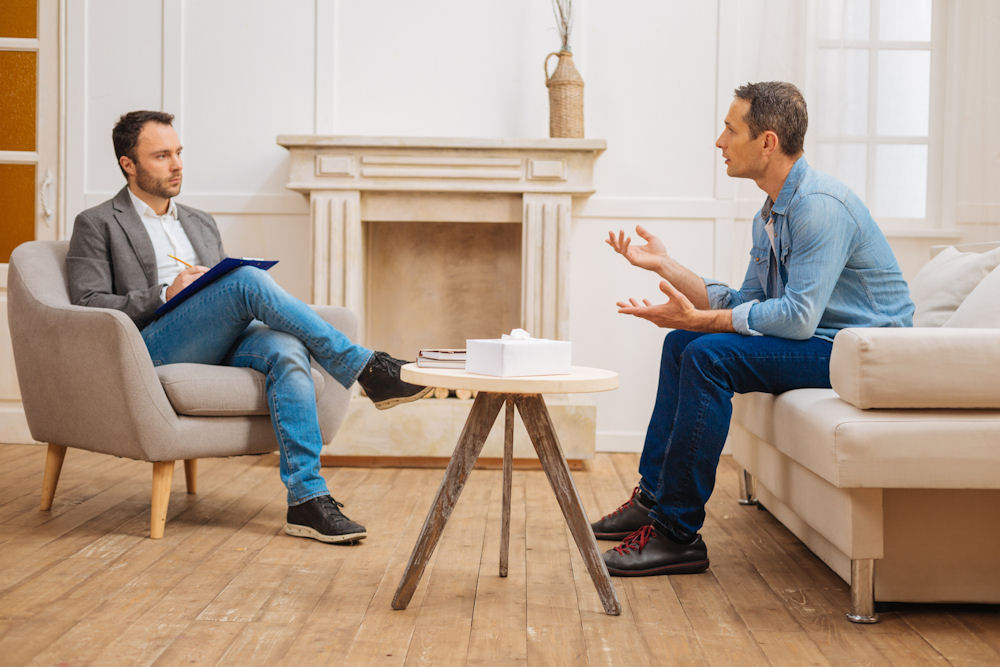 Man comparing online and in-person addiction therapy options